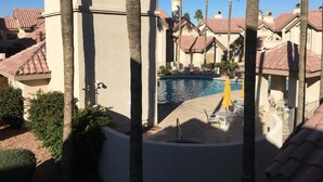 En feriebolig med swimmingpool, palmer og arkitektur i middelhavsstil.