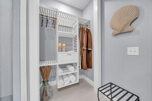 A walk-in closet with open shelves, hanging space, and a mirror.