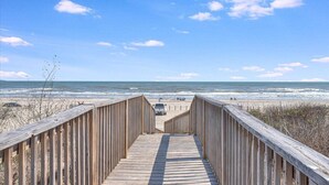 A wooden boardwalk leading to a beach with the ocean in the background. - The Beachside - Banyan Beach, Ocean View & Short walk to Beach (Port Aransas)