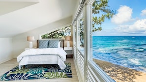 A bedroom with a bed, nightstands, and a view of the ocean. - Haena Beach House: Private Luxury Beachfront Home w/ Breathtaking Views (Hanalei)