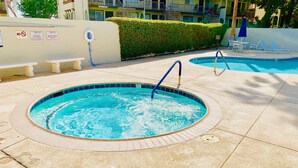 Ein Schwimmbecken mit Whirlpool, Liegestühlen und einem Verbotsschild für Schwimmer.