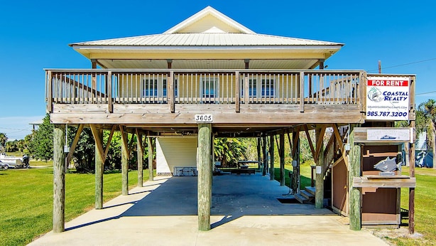 Une maison à deux étages avec un balcon, une pancarte « À louer » et une pancarte « Cayce Club ».