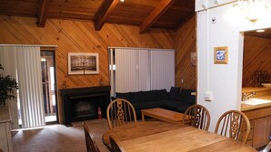 A wooden interior with a dining table, chairs, a sofa, and a fireplace. - Courchevel 8 (Mammoth Lakes)