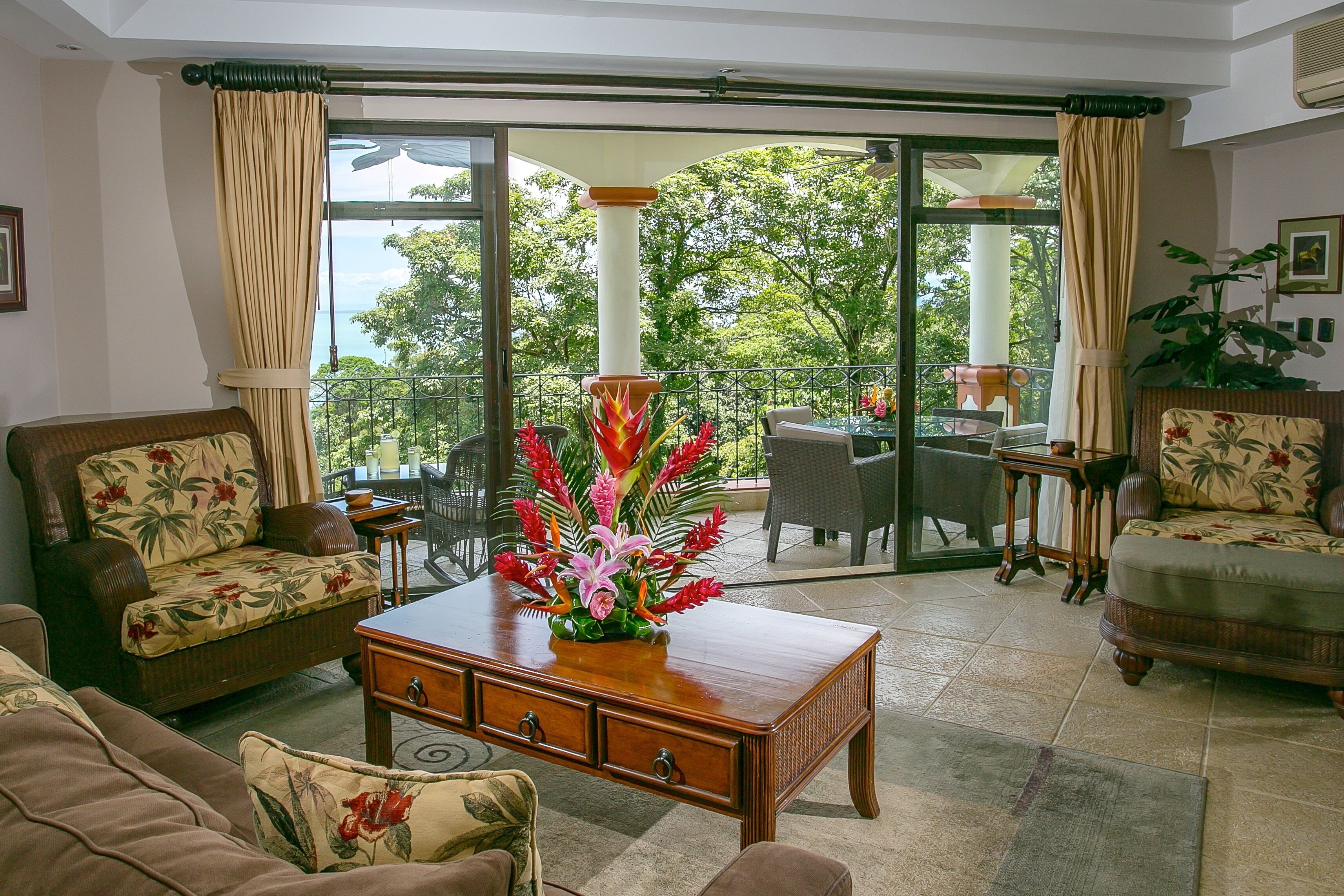 Ein geräumiges Wohnzimmer mit einem großen Schiebeglastür, die auf einen Balkon führt, mit einer Couch, einem Couchtisch und einem Essbereich möbliert.