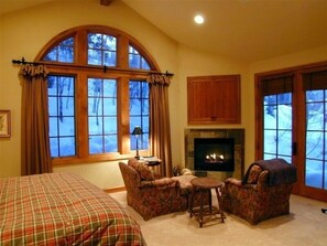 Relax in a traditional room with an arched window, fireplace, and cozy seating area.