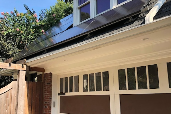 Front view of carriage house; entrance to unit is behind wooden gate