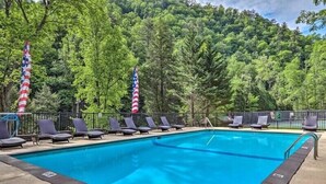 Une piscine avec des chaises longues et des drapeaux américains.