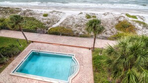 A swimming pool with a view of the ocean and beach. - View Spectacular Sunsets from your balcony overlooking Indian Rocks Beach.  (Indian Rocks Beach)