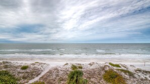 A beach with a sandy shore and sparse vegetation. - View Spectacular Sunsets from your balcony overlooking Indian Rocks Beach.  (Indian Rocks Beach)