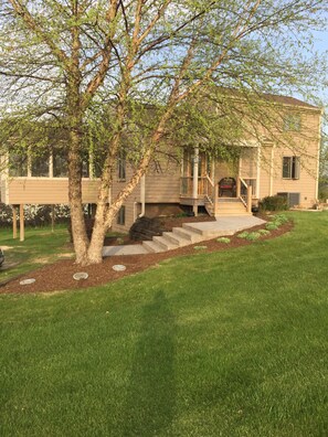A two-story house with a covered porch, a staircase leading to the entrance, and a well-maintained lawn. - Family Friendly Home in The Galena Territory "Access to Territory Amenities" (Galena)