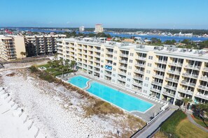 A multi-story hotel with a swimming pool, beach access, and a view of the sea. - Waters Edge 412 • Private Balcony, Platinum Decor, Large Pool, Covered Prkg, Free Beach Svc (Fort Walton Beach)