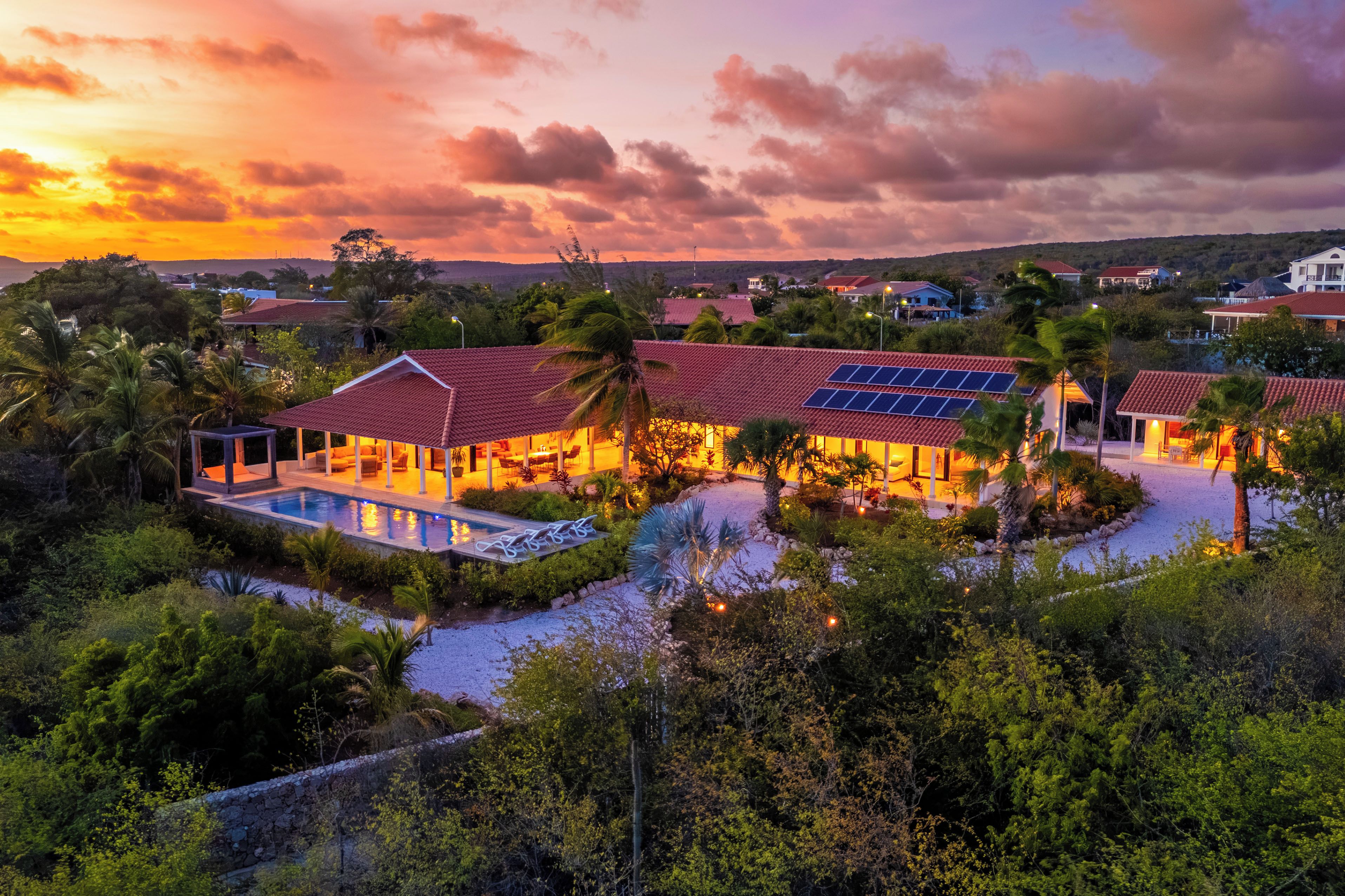 Un resort con varias construcciones, una piscina y paneles solares.
