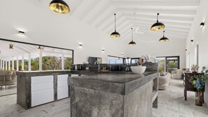 Una cocina amplia con una isla grande, iluminación colgante y vistas al exterior.