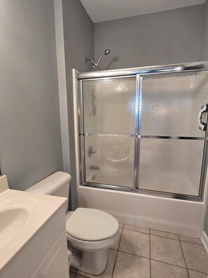 A bathroom with a glass-enclosed shower, a toilet, and a sink. - Beautiful condo. Short walk to the beach!  Linens & Towels included. Beds Made! (Ocean Isle Beach)