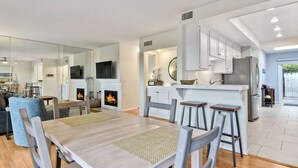 A modern kitchen with white cabinets, a stainless steel refrigerator, and a built-in oven. - Coastal getaway, relaxing Del Mar Townhouse steps from Torrey Pines State Beach (Del Mar)