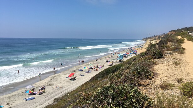 A beach with people, umbrellas, and a clear sky. - Coastal getaway, relaxing Del Mar Townhouse steps from Torrey Pines State Beach (Del Mar)