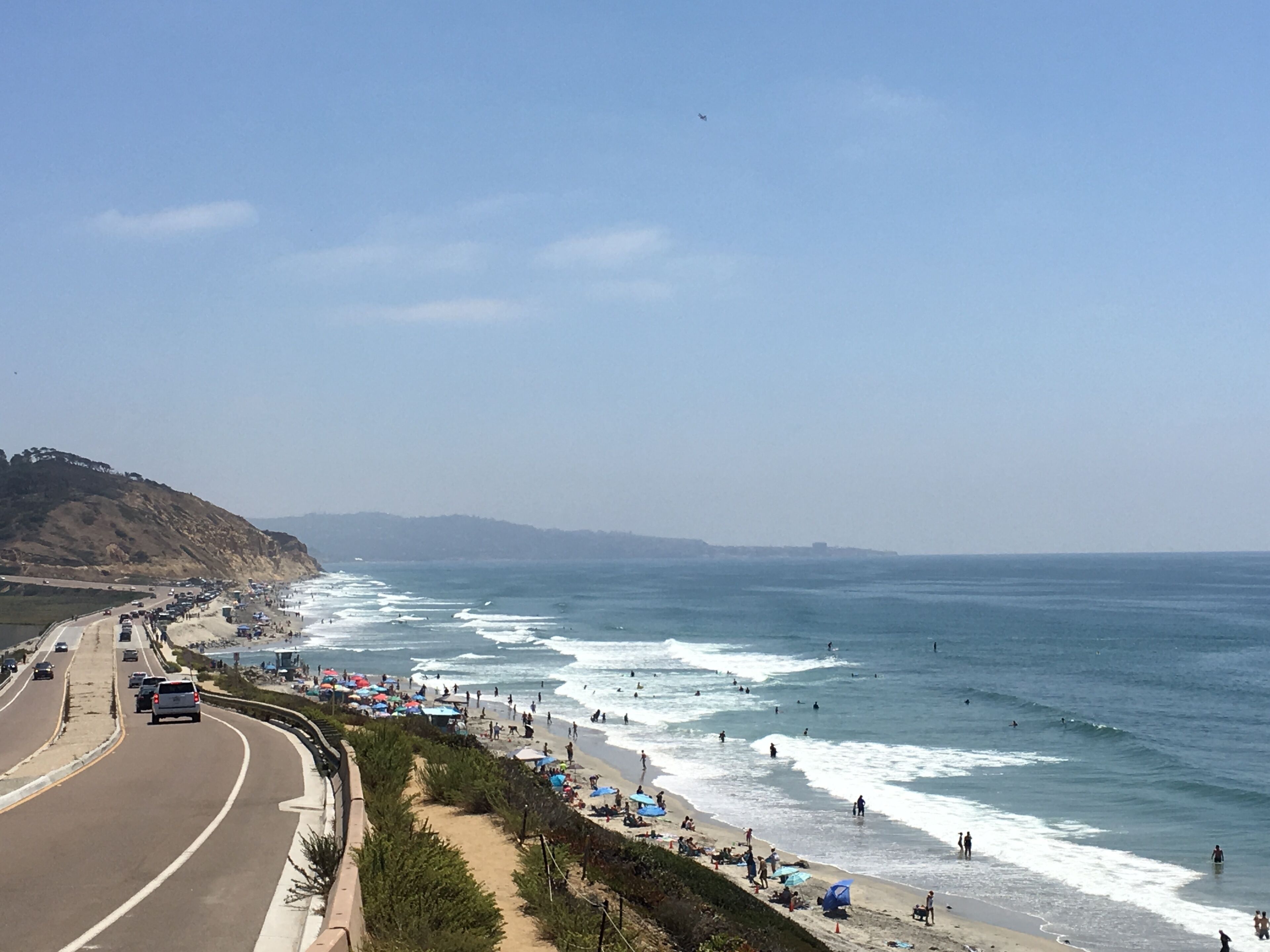 A coastal road with a beach on the right.