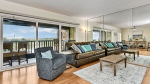 A spacious living room with a large sofa, armchairs, and a wooden coffee table. - Coastal getaway, relaxing Del Mar Townhouse steps from Torrey Pines State Beach (Del Mar)