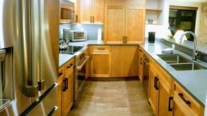 A modern kitchen with stainless steel appliances, wooden cabinets, and a built-in oven. - Family Time, Mountain Views, Perfect Vibes.
Carleton Lodge Patio Condo. (Whistler)