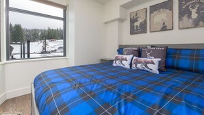 A bedroom with a large bed, a window with a view of a snowy landscape, and three wall-mounted animal-themed wall art pieces. - Family Time, Mountain Views, Perfect Vibes.
Carleton Lodge Patio Condo. (Whistler)