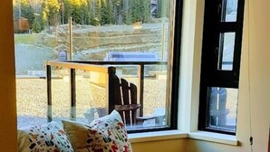 A room with a large window overlooking a forested area. - Family Time, Mountain Views, Perfect Vibes.
Carleton Lodge Patio Condo. (Whistler)