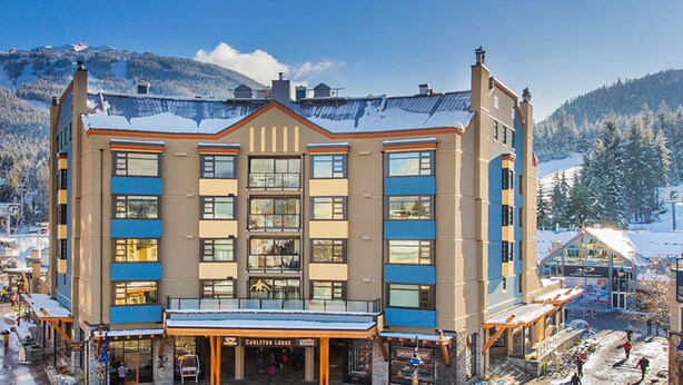 A multi-story hotel with a central atrium, surrounded by snow-covered streets and mountains. - Family Time, Mountain Views, Perfect Vibes.
Carleton Lodge Patio Condo. (Whistler)