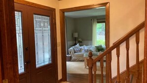 Una escalera de madera conduce a una sala de estar con un sofá y una lámpara.