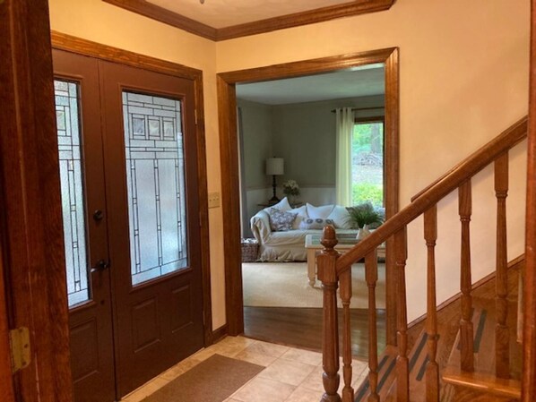 Una escalera de madera conduce a una sala de estar con un sofá y una lámpara.