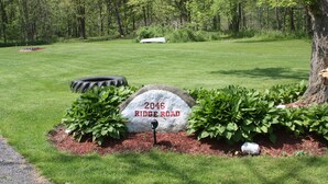 A well-maintained grassy area with a stone marker labeled "2046 Ridge Road."