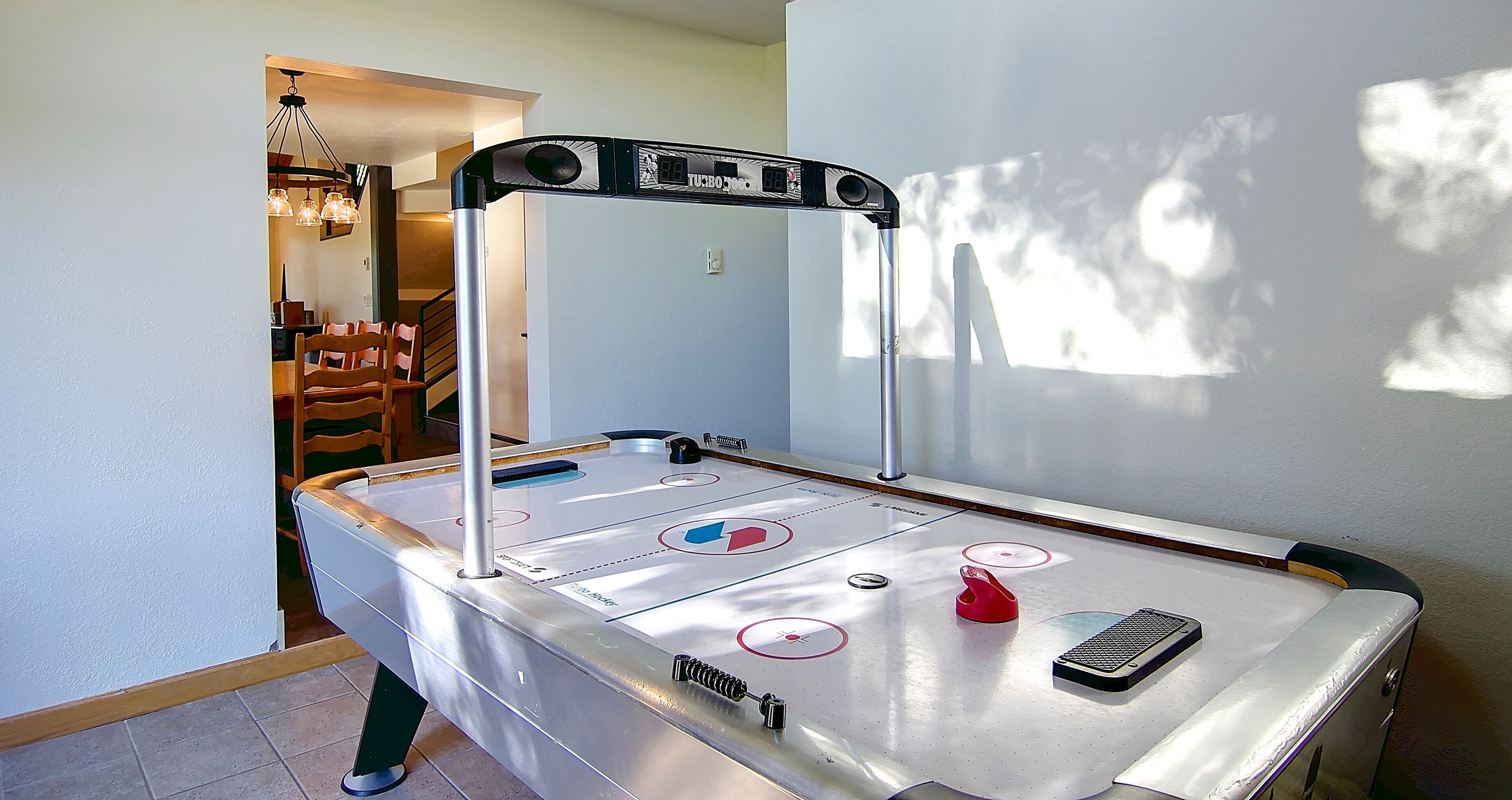A pool table with a table tennis paddle, a remote control, and a red cup.