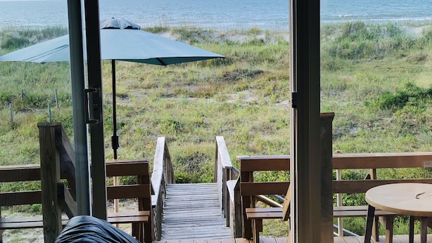 A wooden deck leading to a beach with a view of the ocean. There are picnic tables and a covered area with umbrellas. - Oceanfront Duplex - Sleeps 10 - Great Price!! 3 B/R, 2.5 bath, outdoor shower (Atlantic Beach)