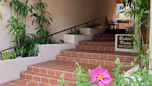 Un escalier menant à un balcon agrémenté de plantes en pot et d’une pancarte indiquant : « Bahia Vista, résidences privées ».