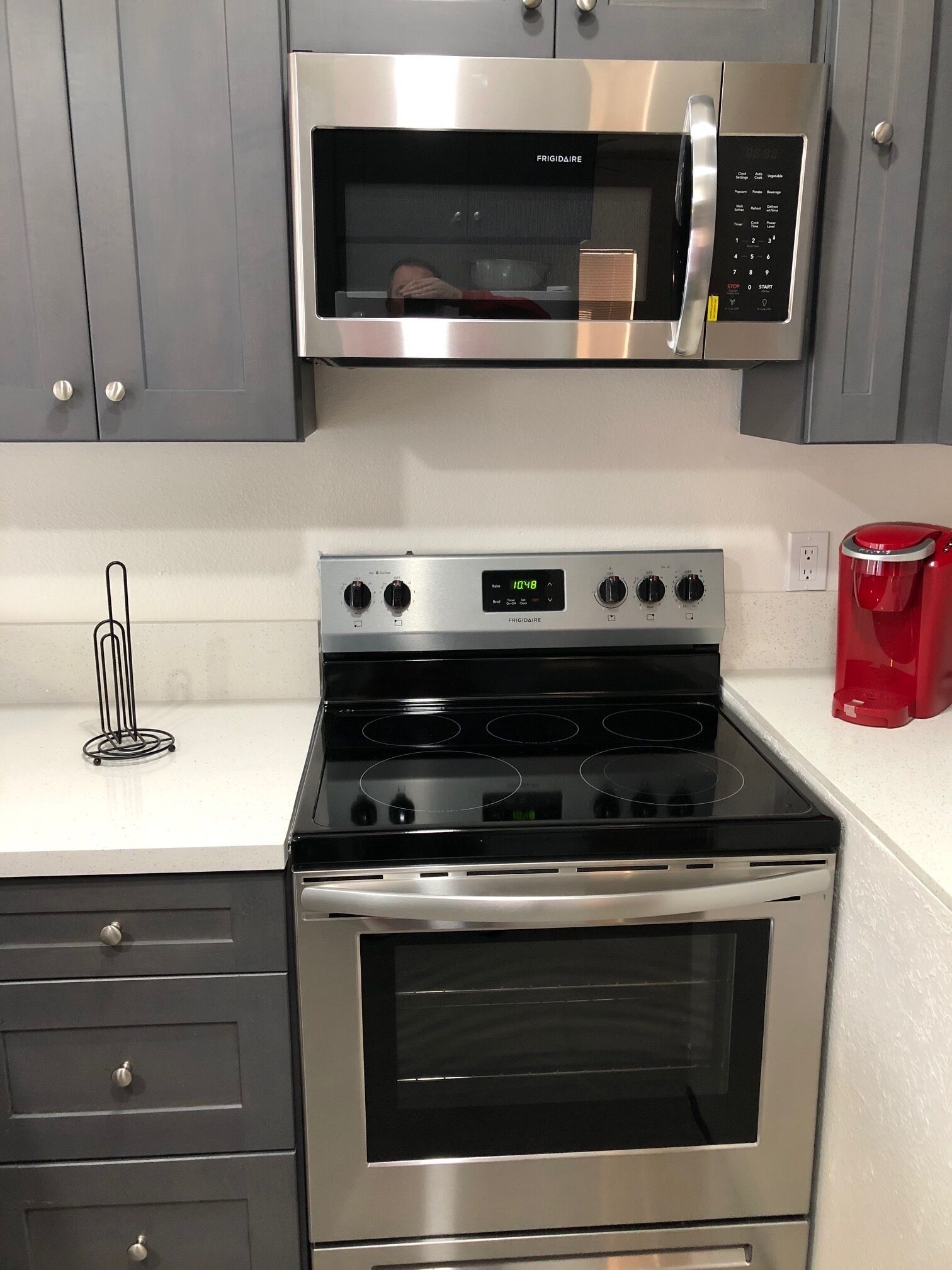 A kitchen with a stainless steel microwave, oven, and stovetop.