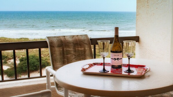 Enjoy a romantic seaside dinner for two on this balcony with a table and chair.