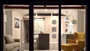 Una sala de estar moderna con un sofá, un sillón y un comedor con una mesa y sillas.