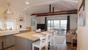 Una cocina moderna con una isla central, un comedor con vistas y un espacio de sala acogedor.