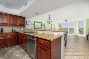 A kitchen with granite countertops, wooden cabinets, and a dishwasher.