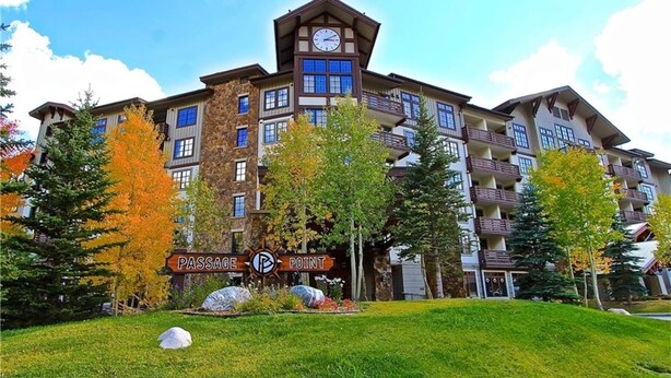 A multi-story hotel with a prominent clock tower, balconies, and a sign reading "Passage Point".