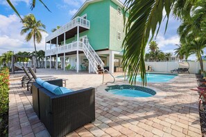 Un resort con piscina, mobiliario exterior y un edificio de dos pisos.