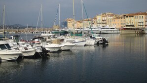 A marina with various boats docked, surrounded by buildings with a Mediterranean architectural style. - Charming Apt On Cote D'azur With Sea Views, Walking Distance To Beach And Shops  (La Croix-Valmer)