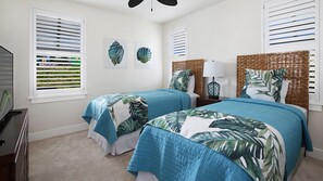 Une chambre avec deux lits, une télévision et des œuvres d’art accrochées au mur.