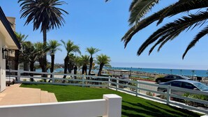 A view of a beachfront property with a white fence, palm trees, and a clear blue sky. - Best Spot in Carlsbad! Private Yard, Ocean View, Walk to beach.  (Carlsbad)