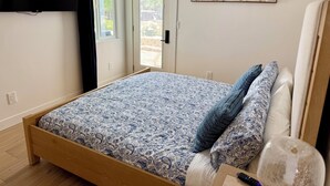 A bedroom with a bed, a TV mounted on the wall, a painting, and a door leading to an outdoor area. - Best Spot in Carlsbad! Private Yard, Ocean View, Walk to beach.  (Carlsbad)