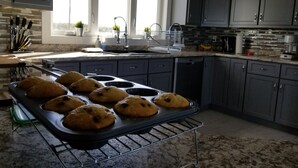 A kitchen with a baking tray of cookies, a sink, and cabinets. - Picturesque oceanfront / beachfront estate, PEI tourism license # 2101170 (Burton)