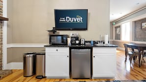 A kitchenette with a flat-screen TV, a microwave, a coffee maker, and a dishwasher.