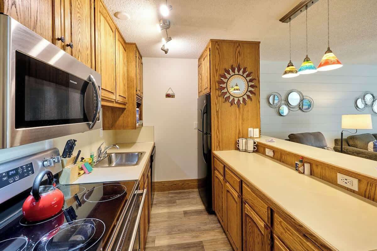 A modern kitchen with wooden cabinets, stainless steel appliances, and a central island.