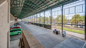 Un espace de stationnement couvert, doté d’un toit en métal et de grandes fenêtres.