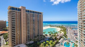 A high-rise hotel with multiple balconies overlooking a beach and ocean. - Ilikai Hotel, Ocean Front, Hip Real 1 BDR,  City View, Best Surf in Waikiki (Honolulu)