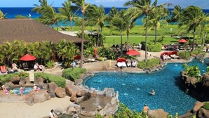 A resort with a large pool, palm trees, and a view of the ocean. - Honua Kai Ocean Front 3/3 condo, Hokulani 350 (Lahaina)