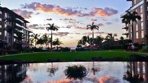 A hotel with a pool, palm trees, and a sunset view. - Honua Kai Ocean Front 3/3 condo, Hokulani 350 (Lahaina)